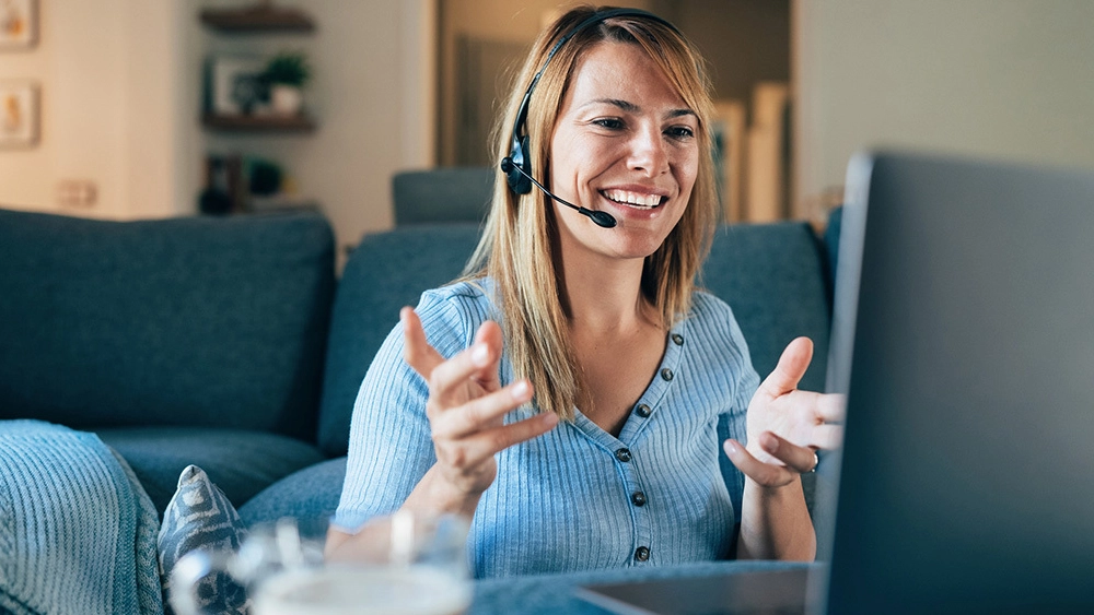 Stock image of Business Worker on headset sitting at her computer in Collaboration session