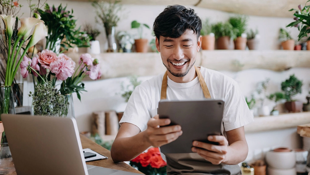 Stock image of florist looking at a tablet