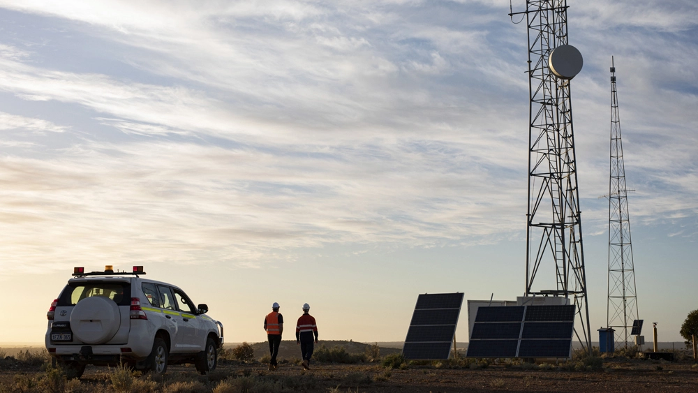 Photo of Vocus workers at dusk. There's a network tower in the background