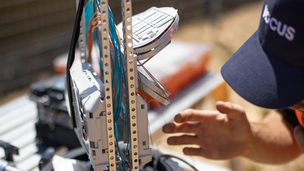 Photo of a Vocus Networks worker. He has a Vocus logo on his hat