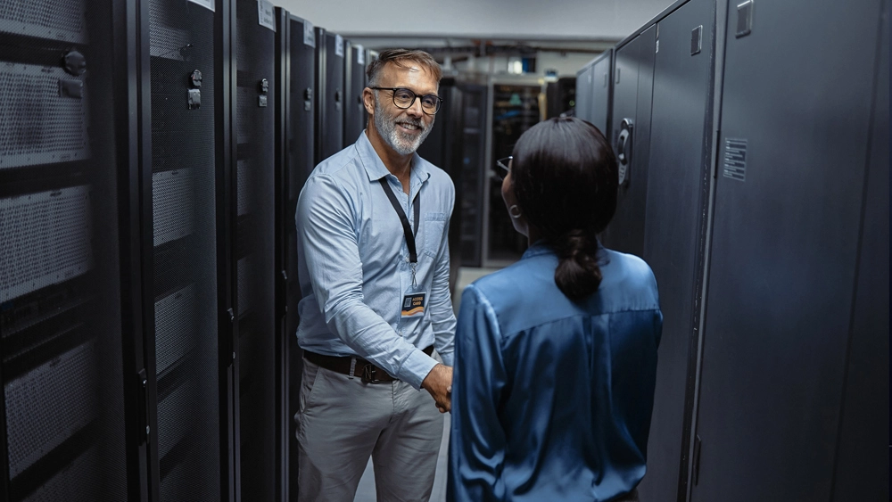 This is an image of two office workers shaking hands in Data Centre