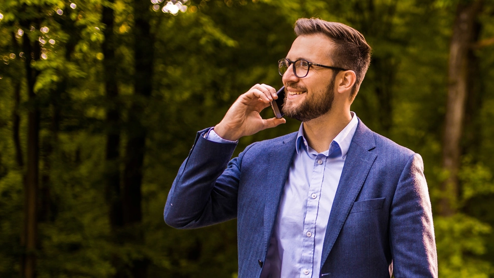 Stock image of man in suit on mobile phone outside
