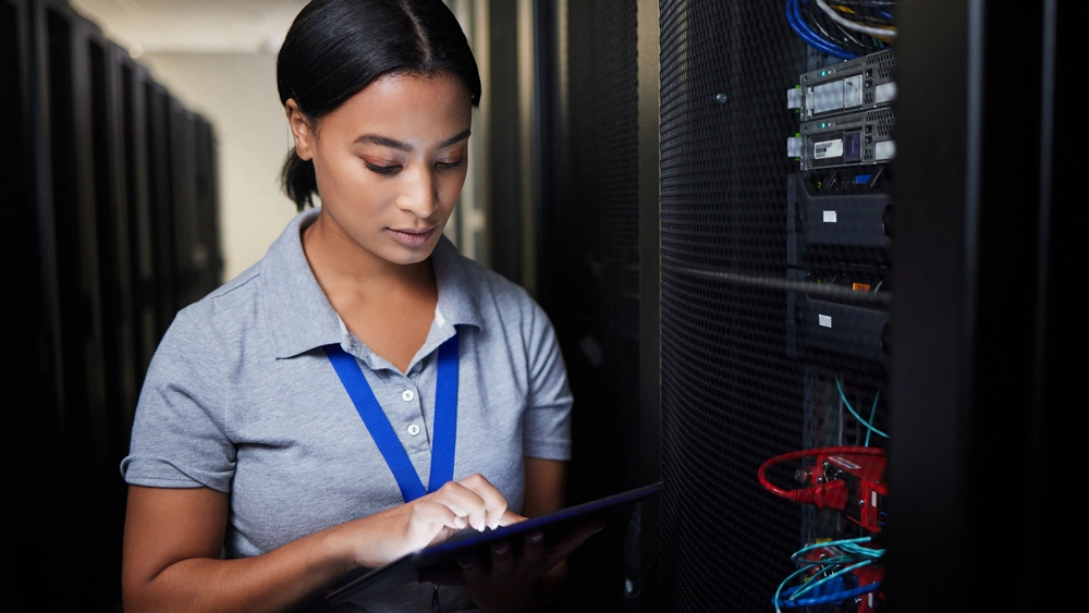 Stock image of Woman in Data Centre looking at laptop
