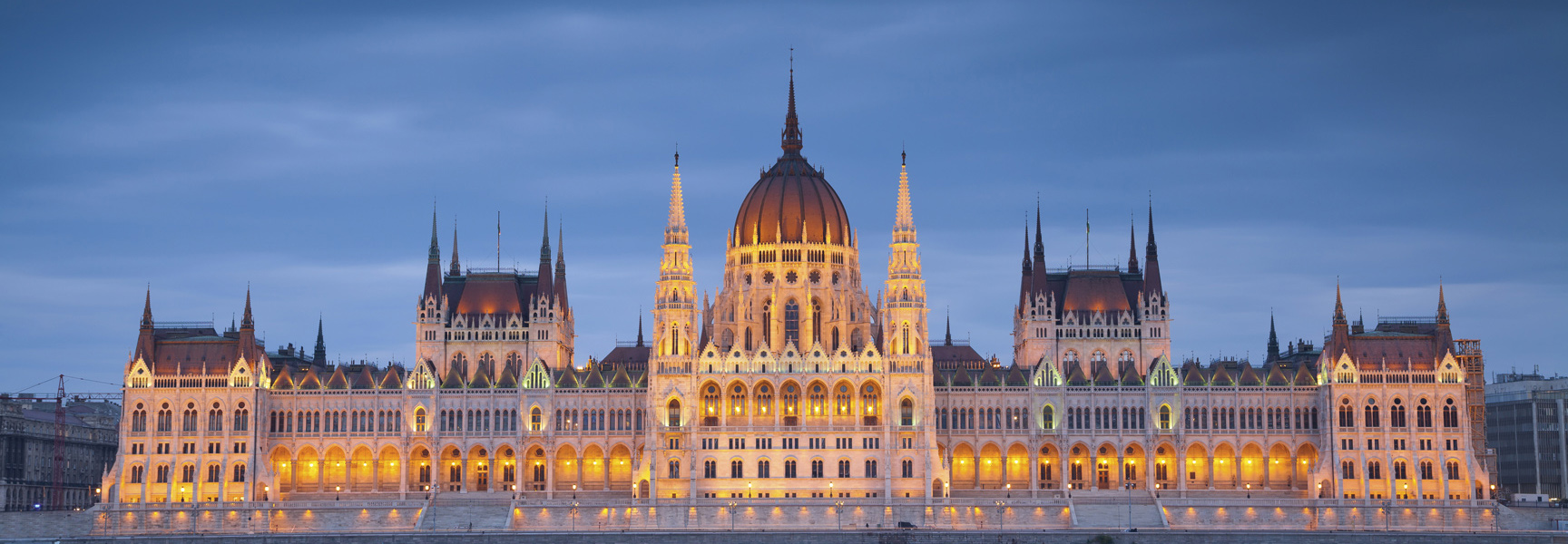 The grand Hungarian Parliament building in Budapest, Hungary, is brightly illuminated at dusk.
