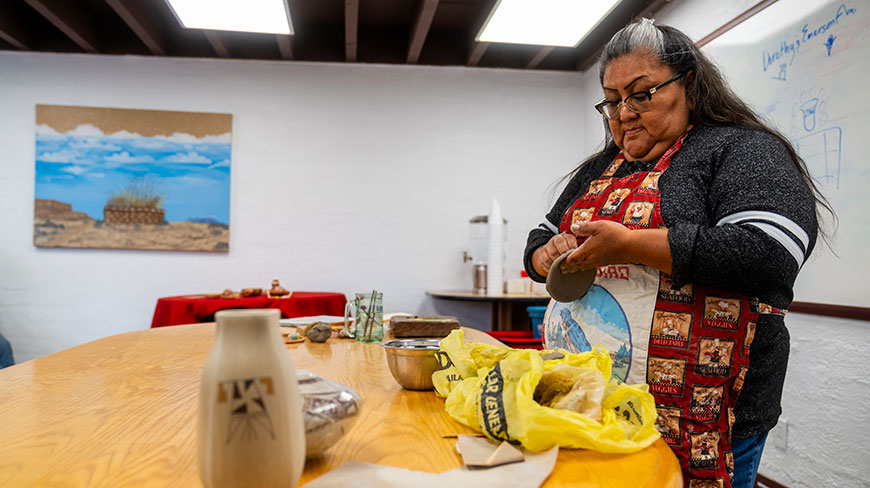 A woman crafts traditional pottery at the Hopi Cultural Center in Arizona, reflecting the ancient traditions of the Hopi and Navajo cultures.
