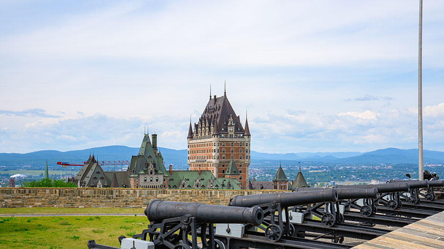 Historic cannons at La Citadelle overlook the Château Frontenac and the architecture of Québec City.