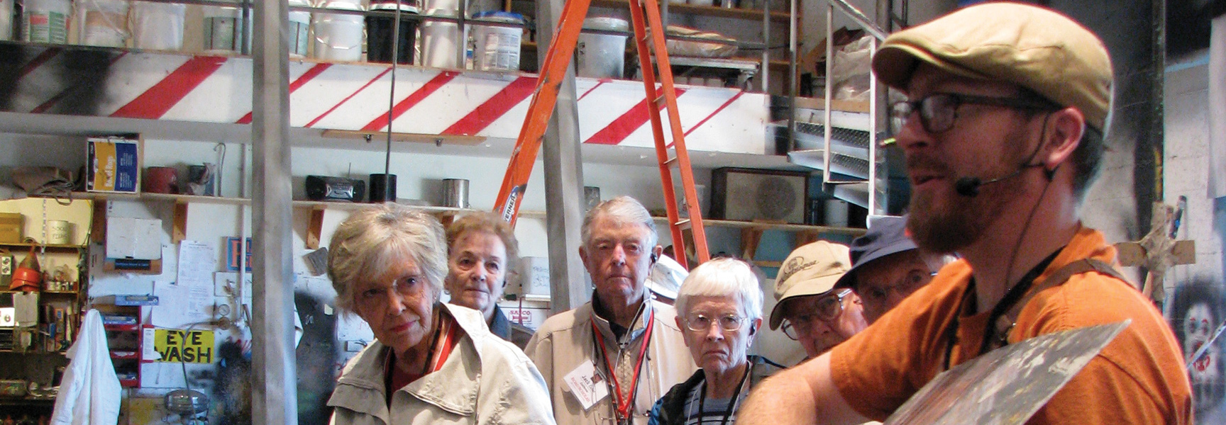 A man gives a tour of a theater workshop to a group of older adults in Ashland, Oregon.