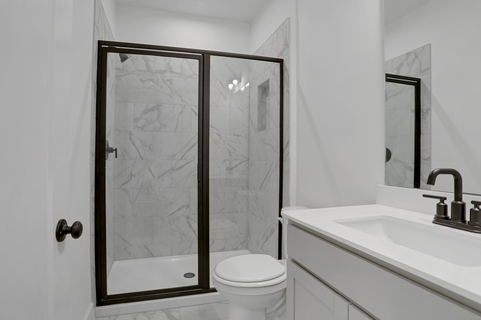 secondary bathroom with gray cabinets and tile flooring