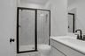 secondary bathroom with gray cabinets and tile flooring