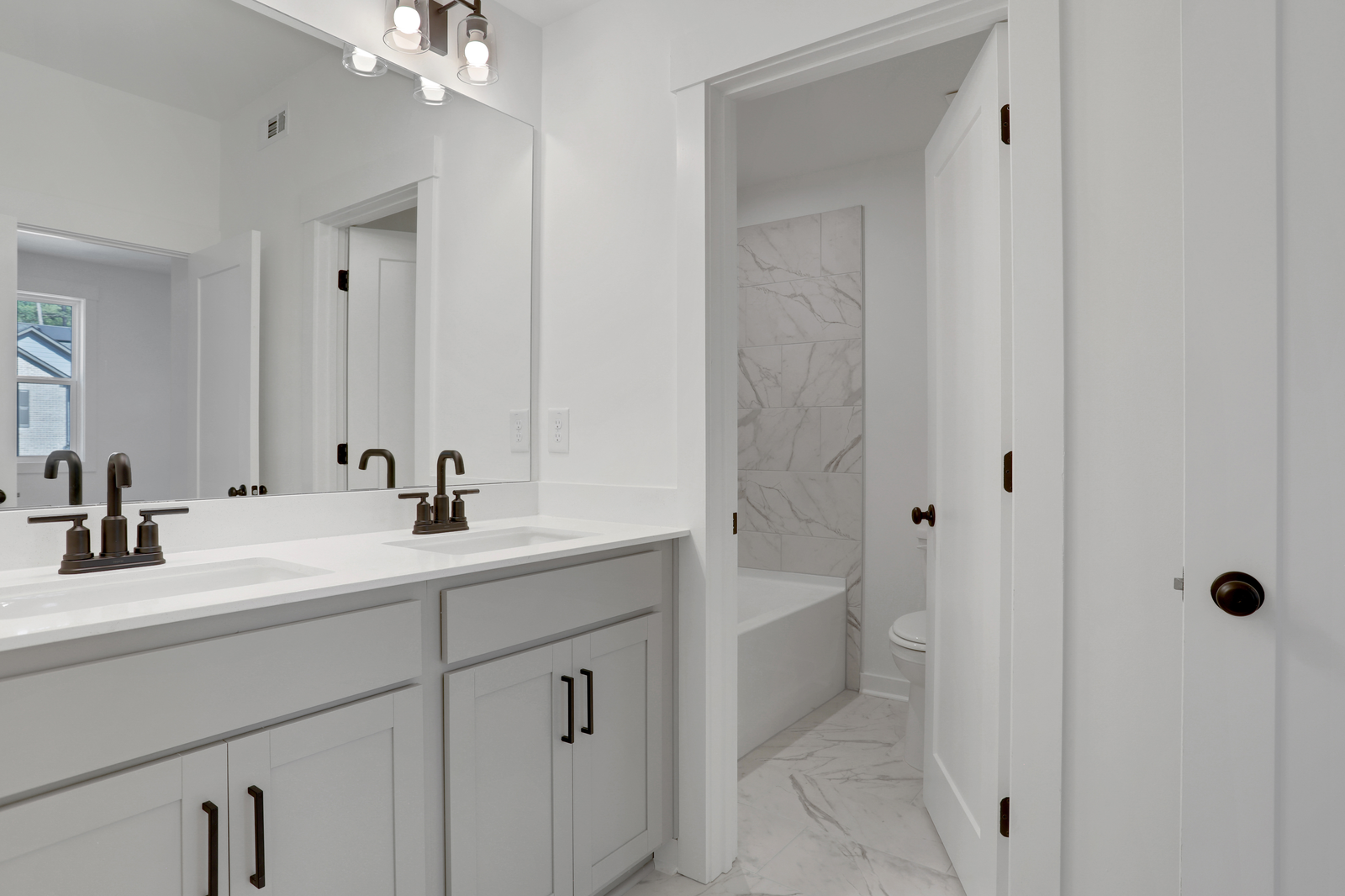 secondary bathroom with gray cabinets and tile flooring