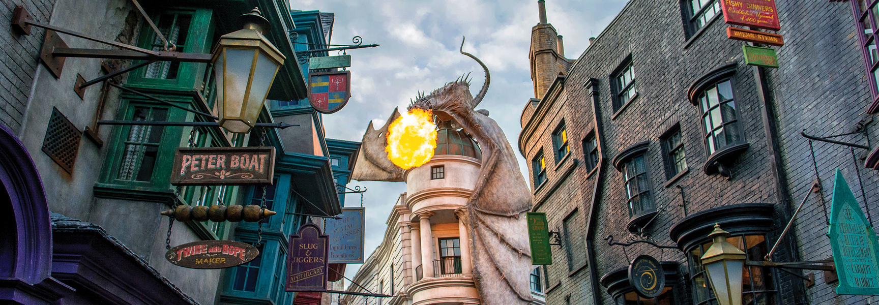 A large dragon breathes fire from atop a building in Diagon Alley at The Wizarding World of Harry Potter in Florida.