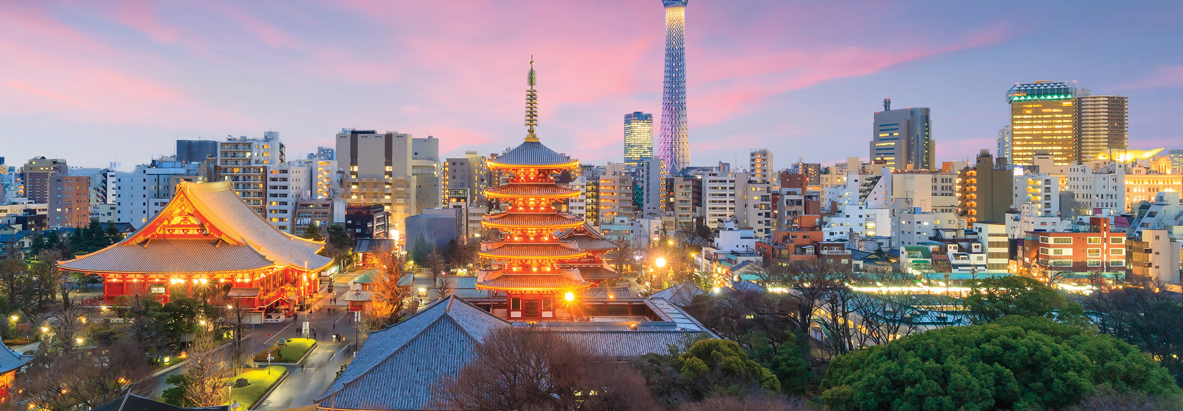 A brightly lit pagoda and temple in Japan stand out against the modern Tokyo city skyline and Skytree at sunset.