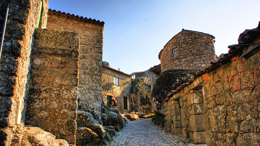 A narrow cobblestone street winds through historic stone buildings in a village in Costa Rica.