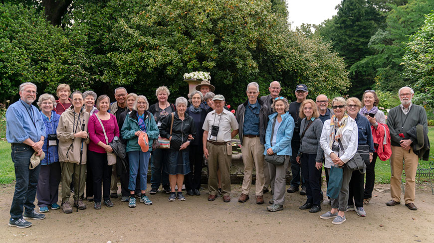 A group of travelers poses for a photo together in a lush garden during their program in Costa Rica.