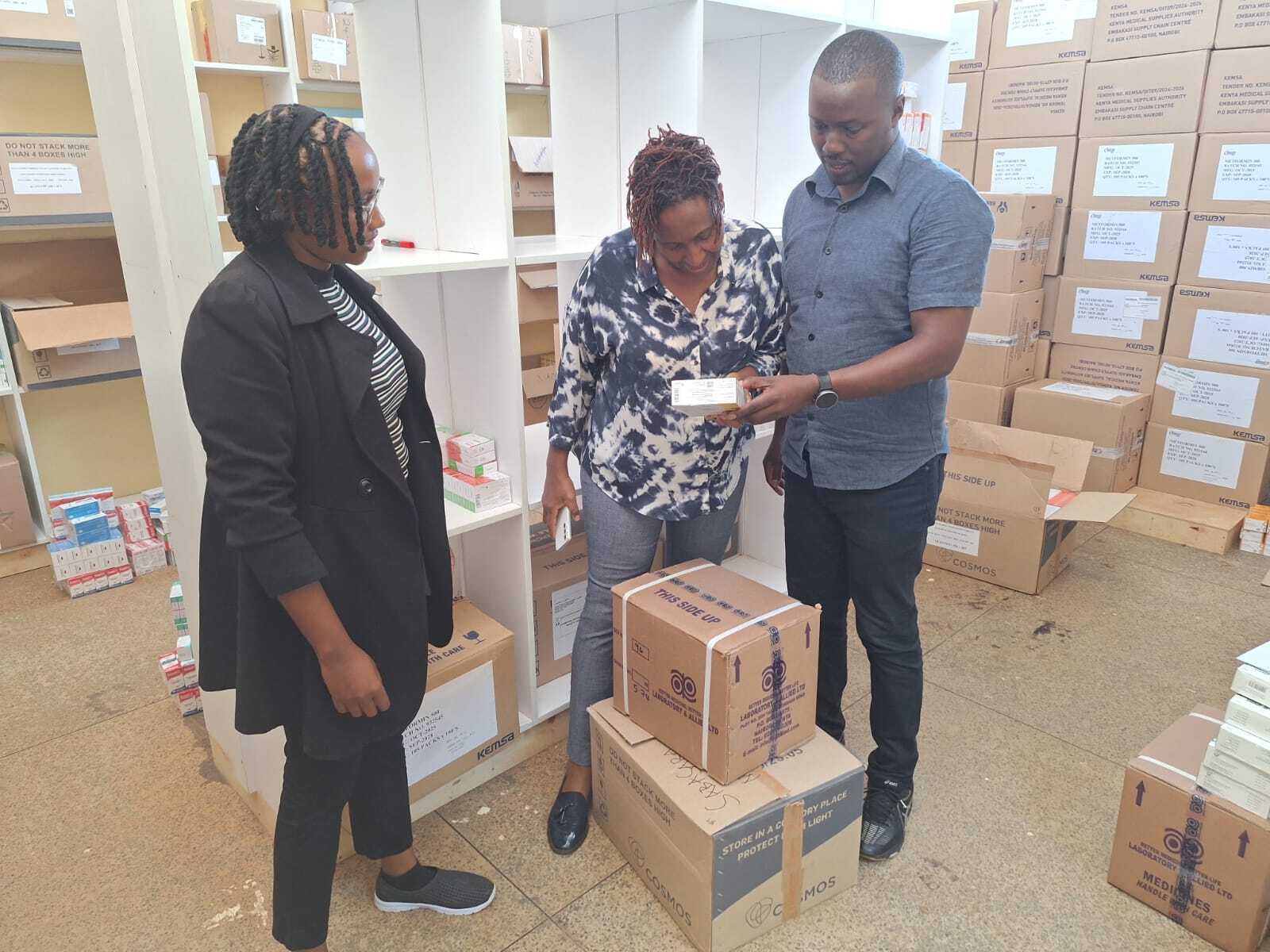 3 people in warehouse looking at boxes together
