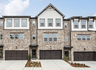 front of 3-story townhome with brick and dark accents