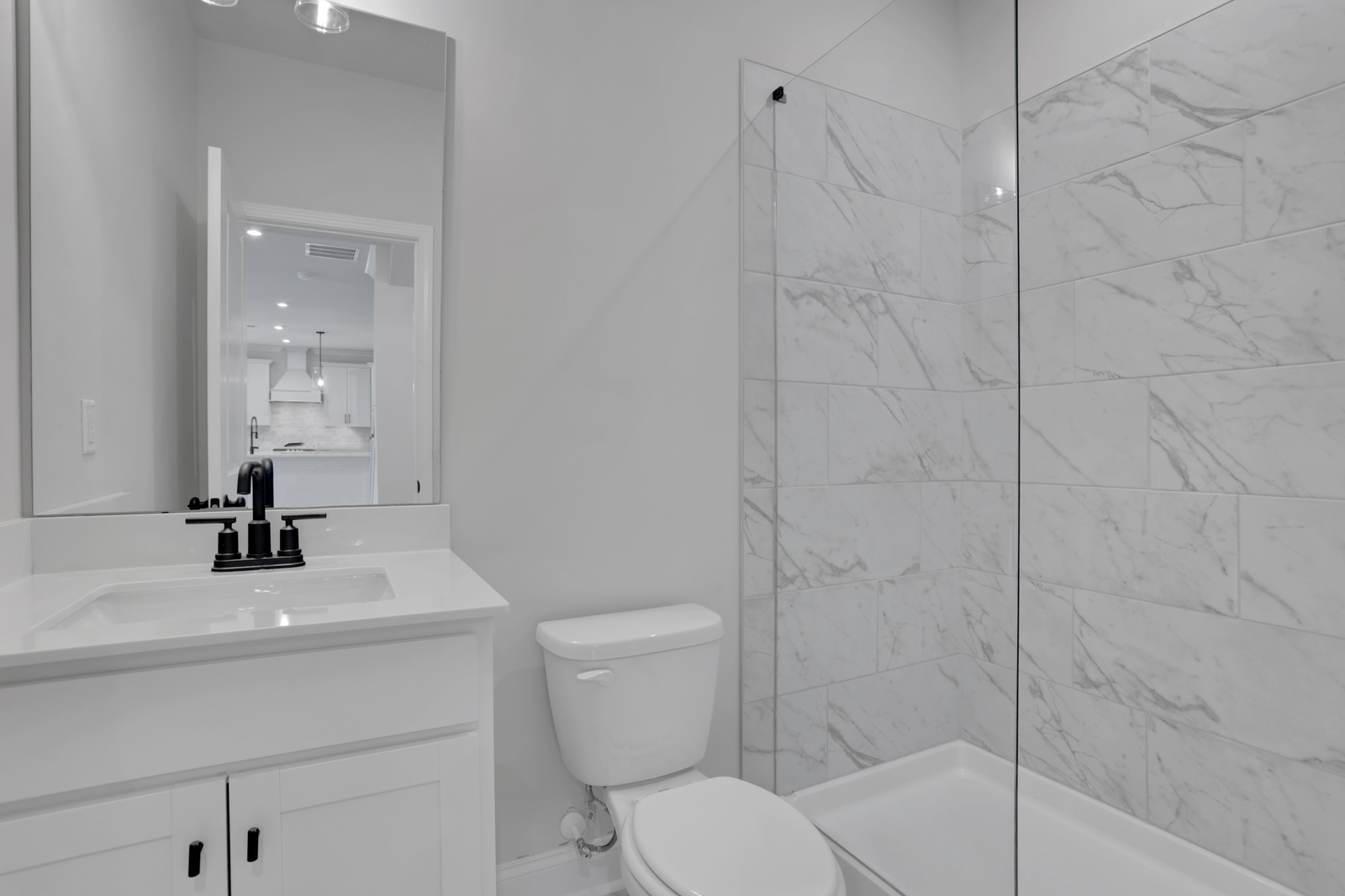 secondary bathroom with white cabinets and tile flooring