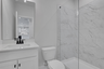 secondary bathroom with white cabinets and tile flooring