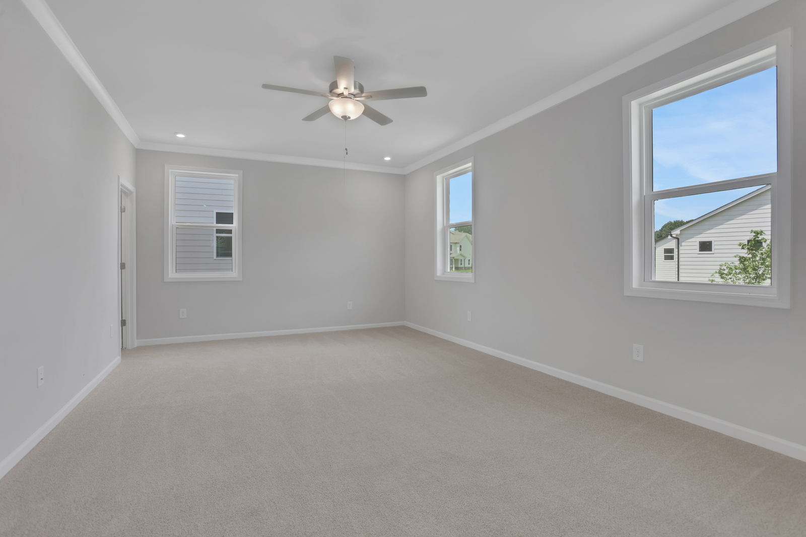 primary bedroom with windows and carpet