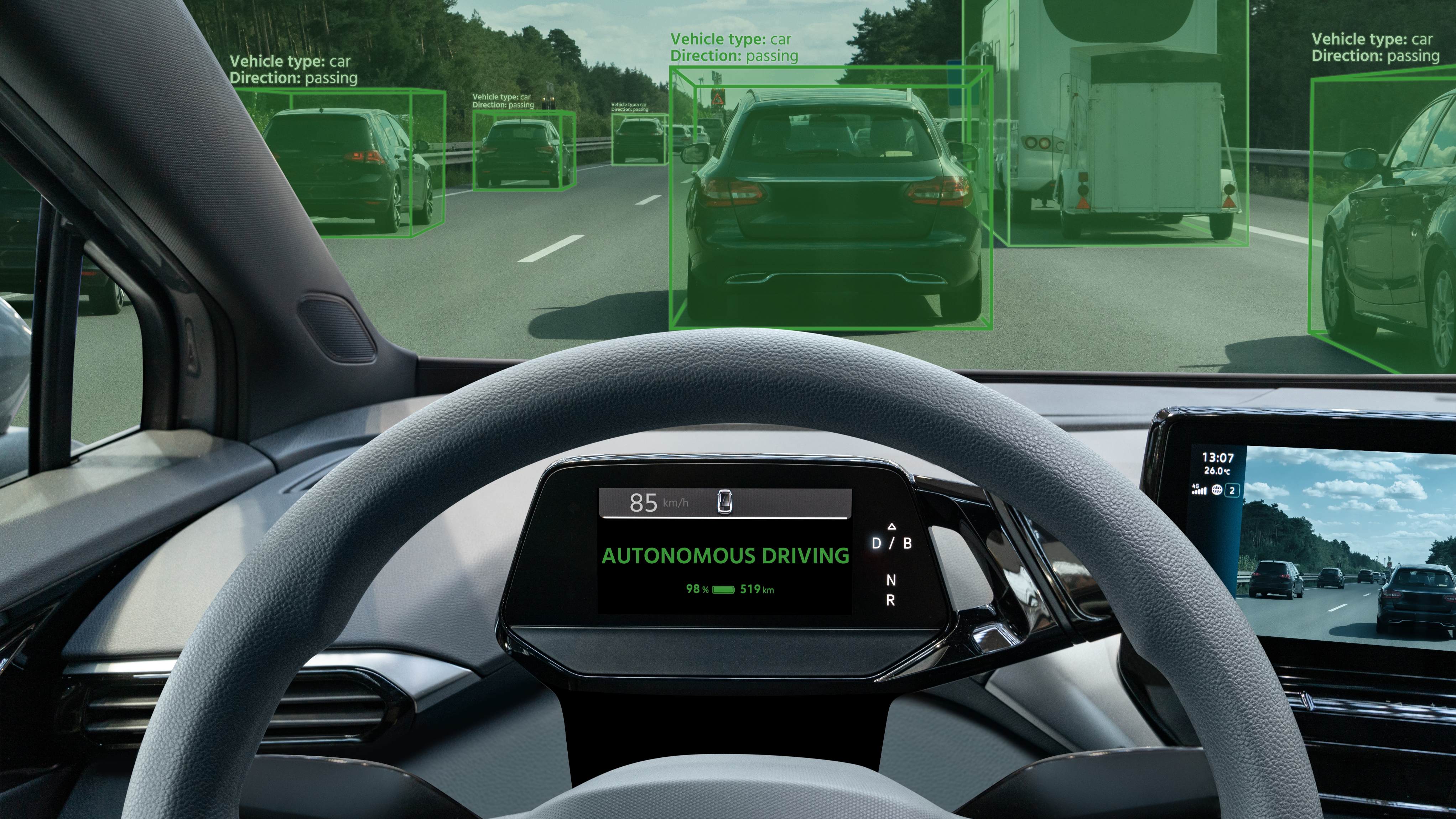View from inside a car in autonomous driving mode, with green boxes highlighting vehicles on the road ahead.