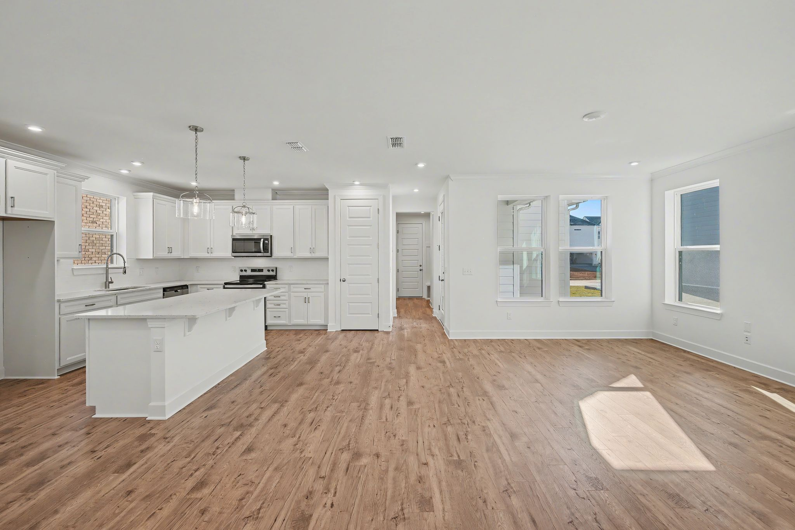 kitchen with island, white counters, white cabinets, and stainless steel appliances