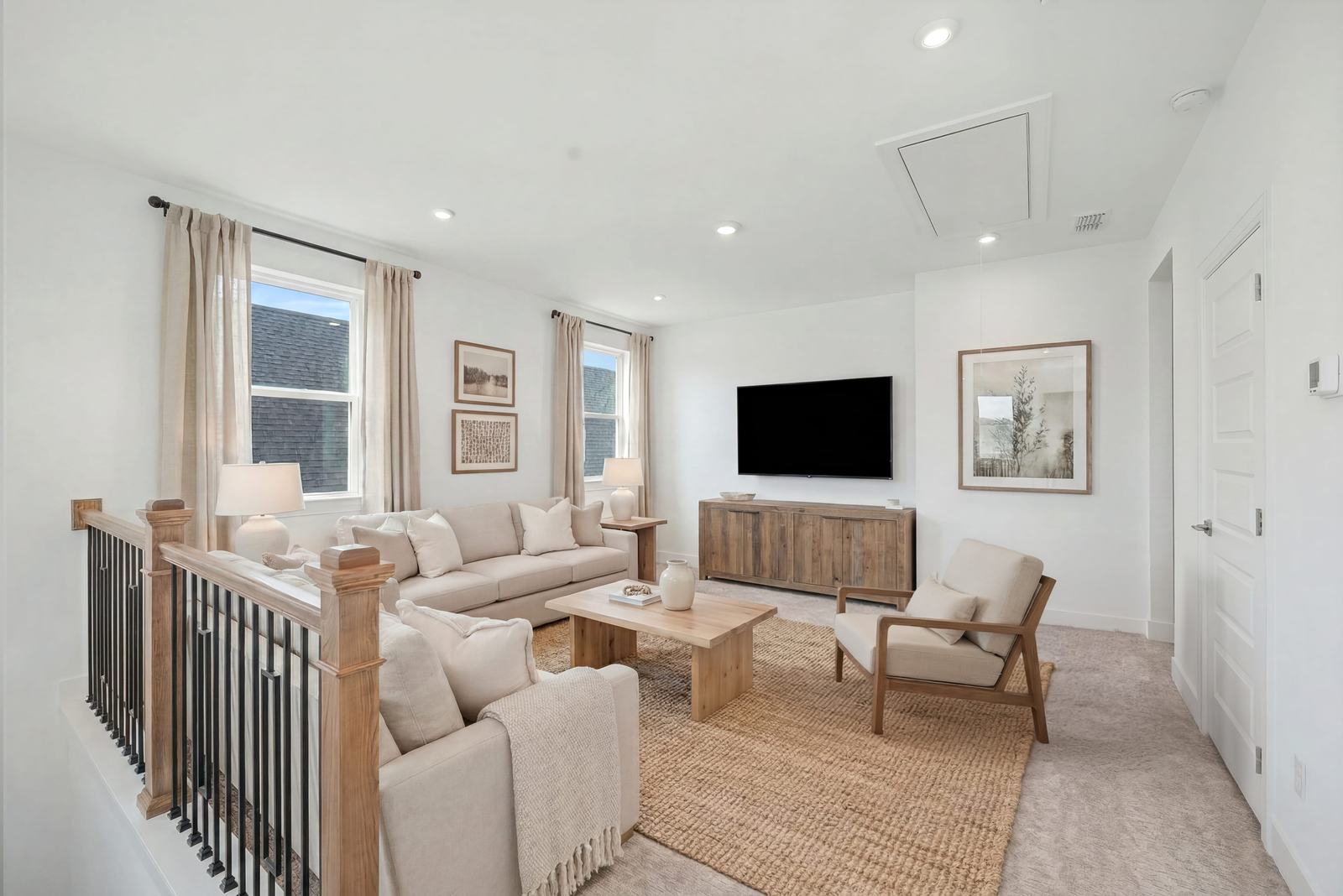 loft space with sofas, accent furniture, a tv, and large windows