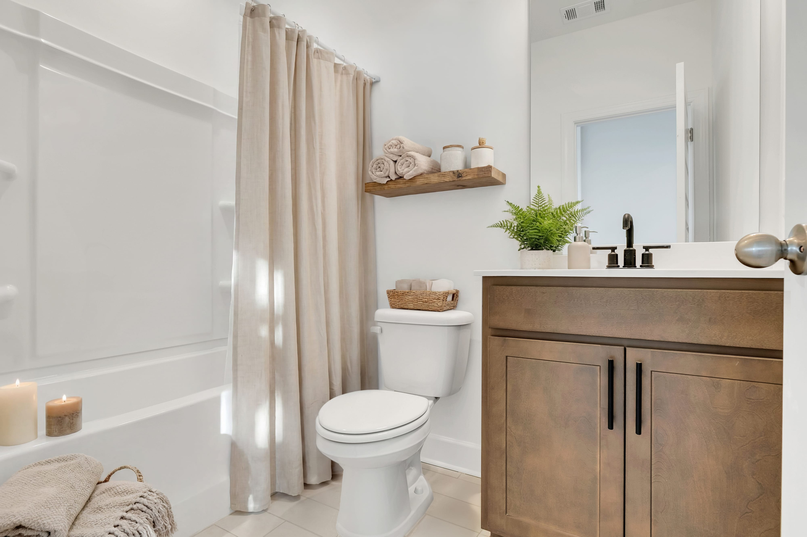 secondary bathroom with wood cabinets, white countertops, and a shower and tub combination