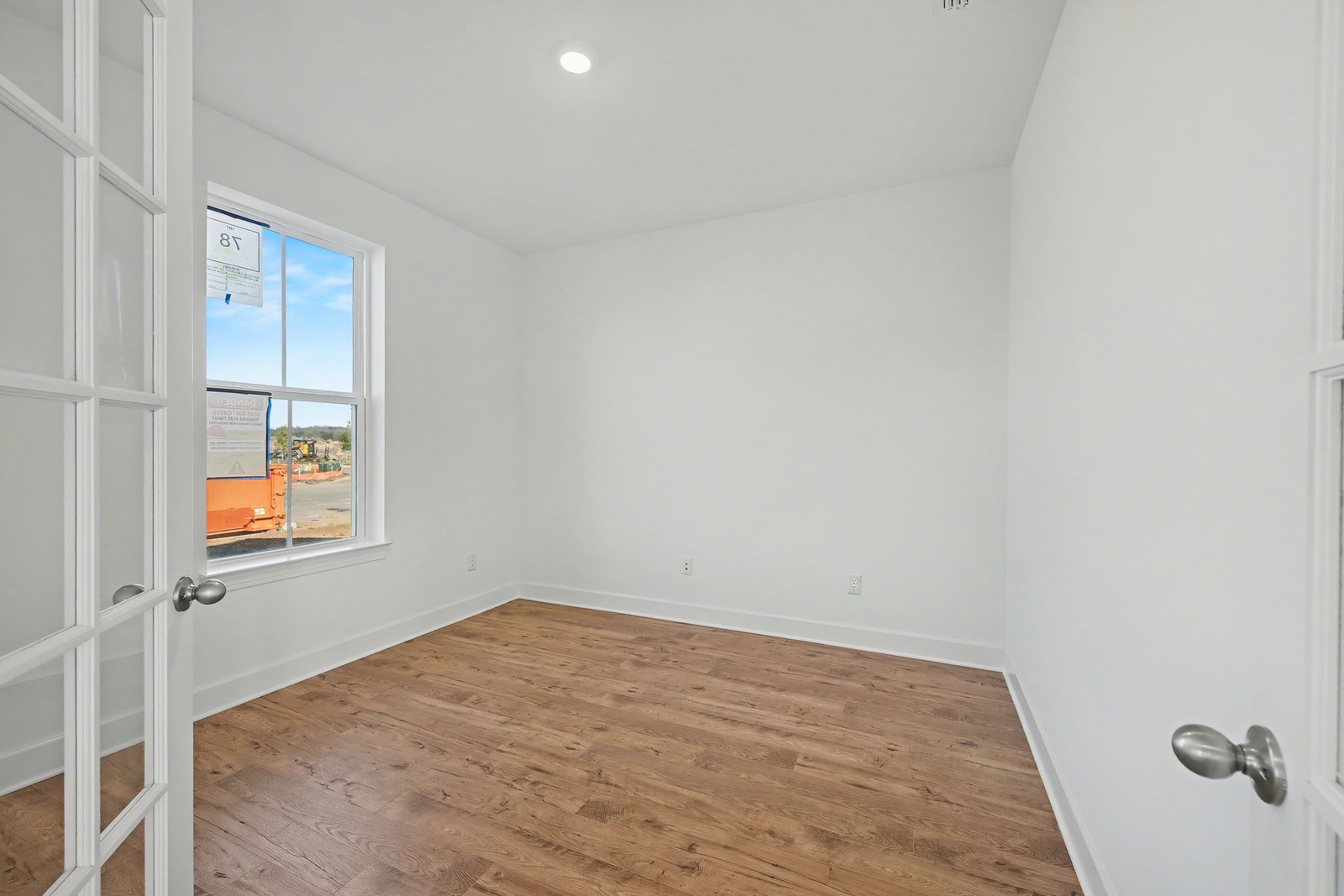 study with french doors, windows, and light wood flooring