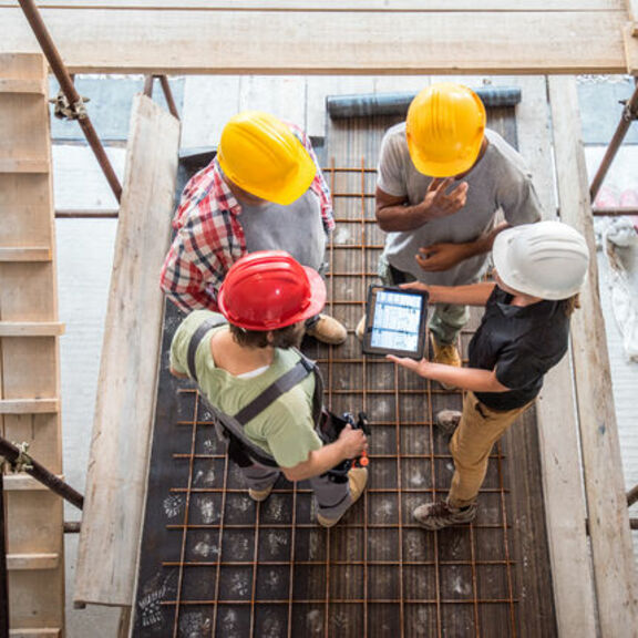 Architect explaining building plans to contractors at a worksite 