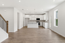 dining room with wood flooring, a view of the kitchen, and open to the great room