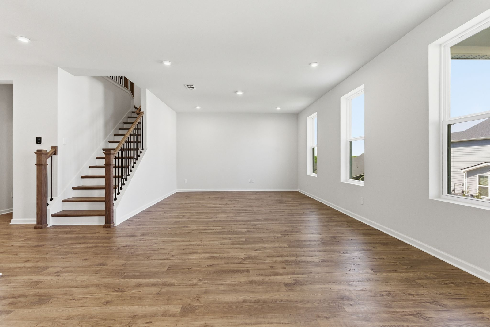 great room with oak wood staircase, and large windows