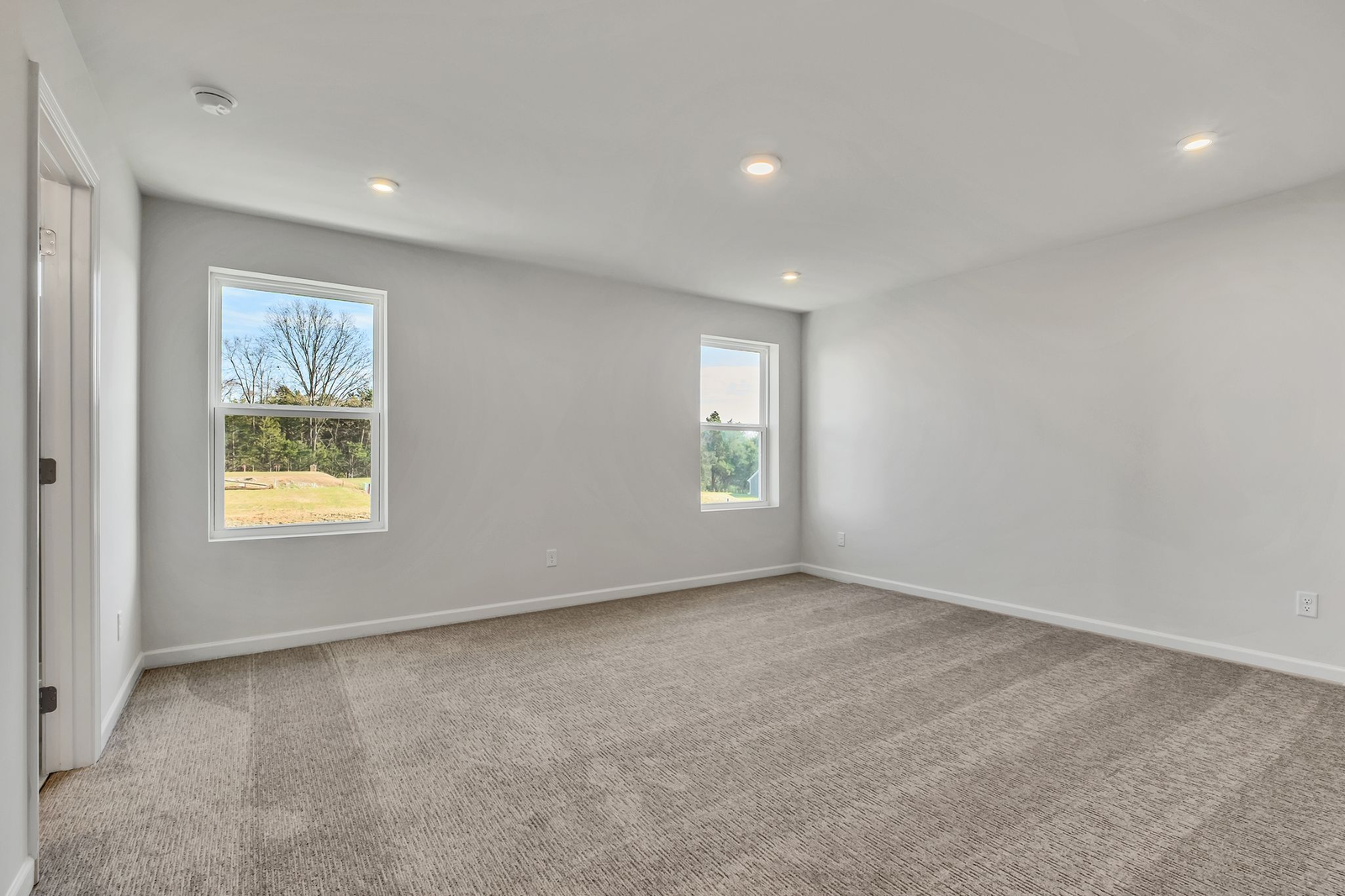 primary bedroom with carpet flooring and light filled windows