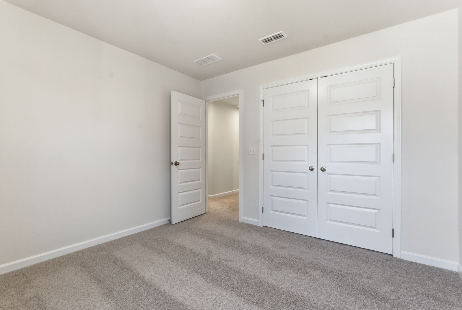 secondary bedroom with large windows and carpet