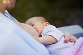Image of newborn baby being breastfed to illustrate article on breastfeeding and periods.