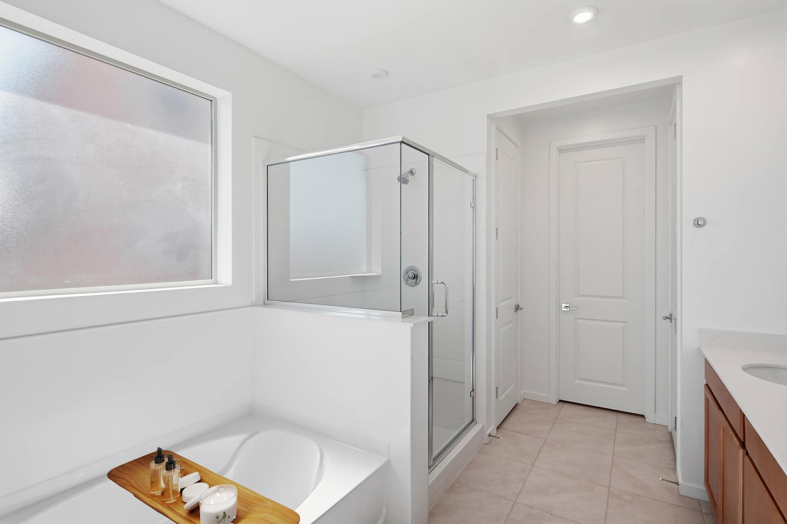 spacious bathroom with a walk-in shower, soaking tub, and brown cabinets
