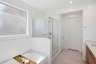 spacious bathroom with a walk-in shower, soaking tub, and brown cabinets