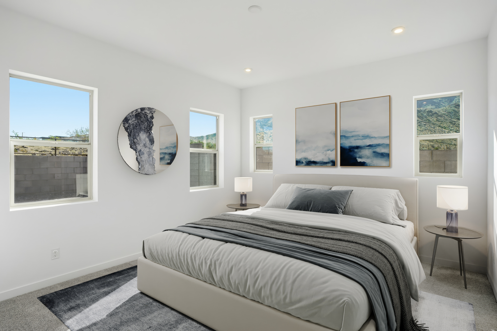 spacious bedroom with large bed, wooden nightstands, and ocean artwork