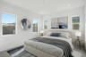 spacious bedroom with large bed, wooden nightstands, and ocean artwork