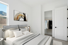 bedroom with a large bed, grey bed covers, and nightstands with lamps