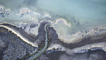 Top-down view of a beach with bright blue water 