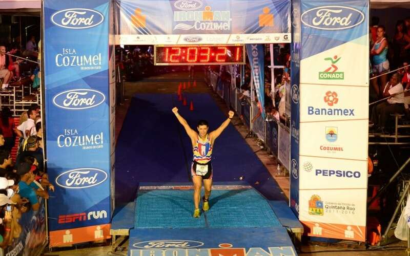 Dr. Jose Beltran crossing the finish line at an Ironman race