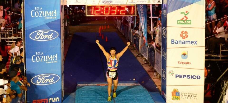 Dr. Jose Beltran crossing the finish line at an Ironman race