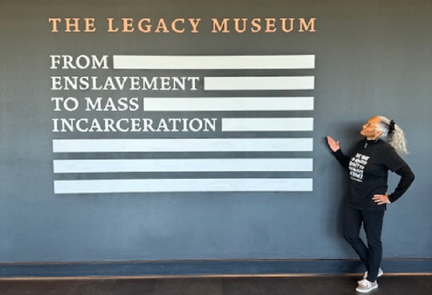 Elaine points towards a sign for the Legacy Museum