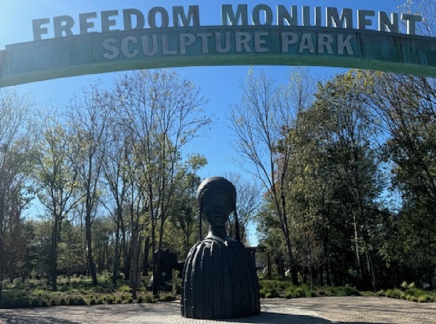 A statue stands at the entrance of the Freedom Monument Sculpture Park