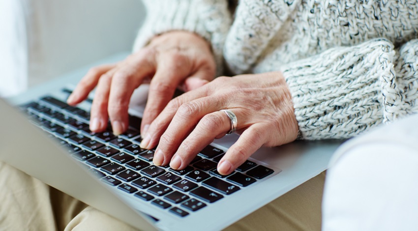 Hands typing on a laptop