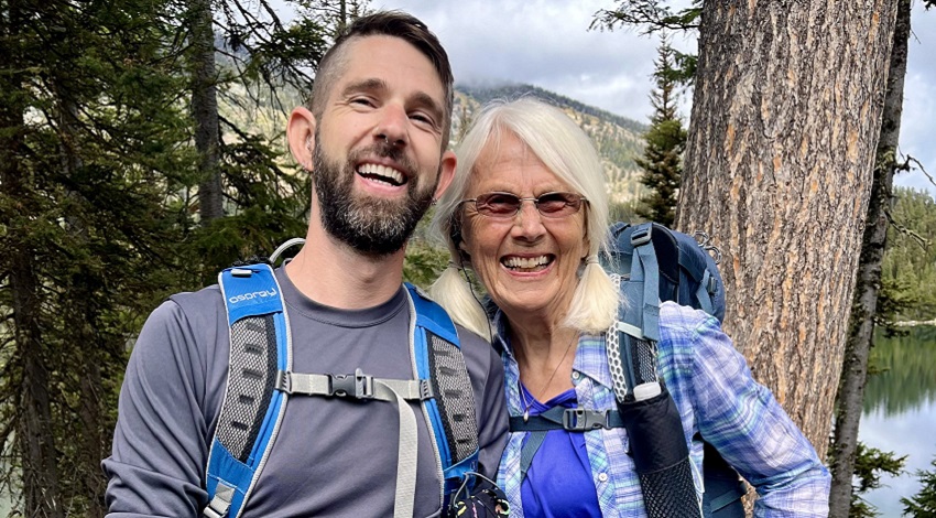 Mary and James smile for the camera on a hike