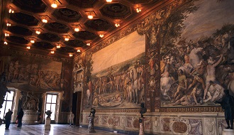 Large paintings cover the walls of a museum, with statues lining the walls