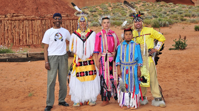 Richard stands with Native Americans dressed in traditional clothing