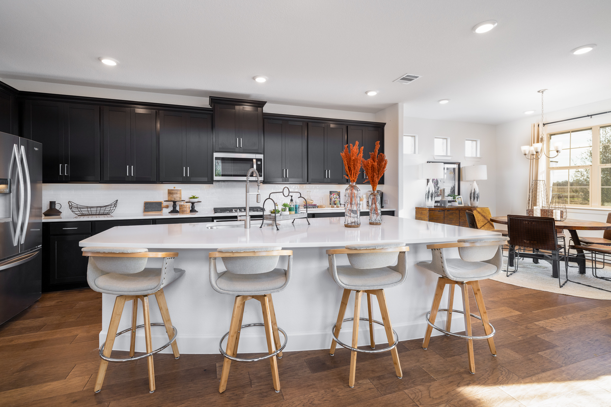 open kitchen with dark cabinets and wood floors