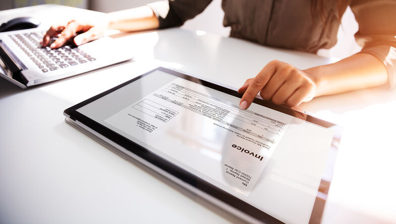 Businesswoman checking invoice on tablet